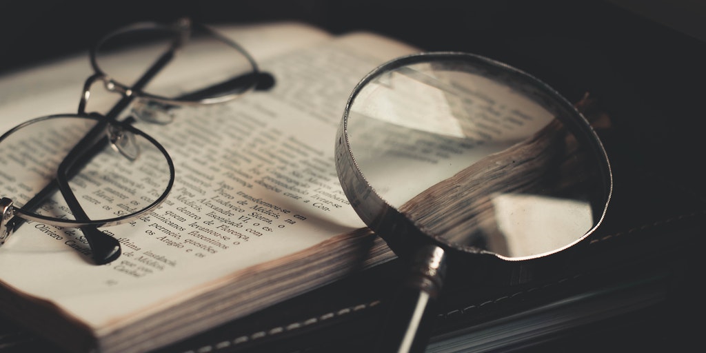 Reading glasses and magnifying glass on an open bible