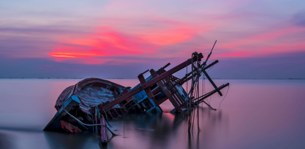 A rusty sunken ship resting on its side