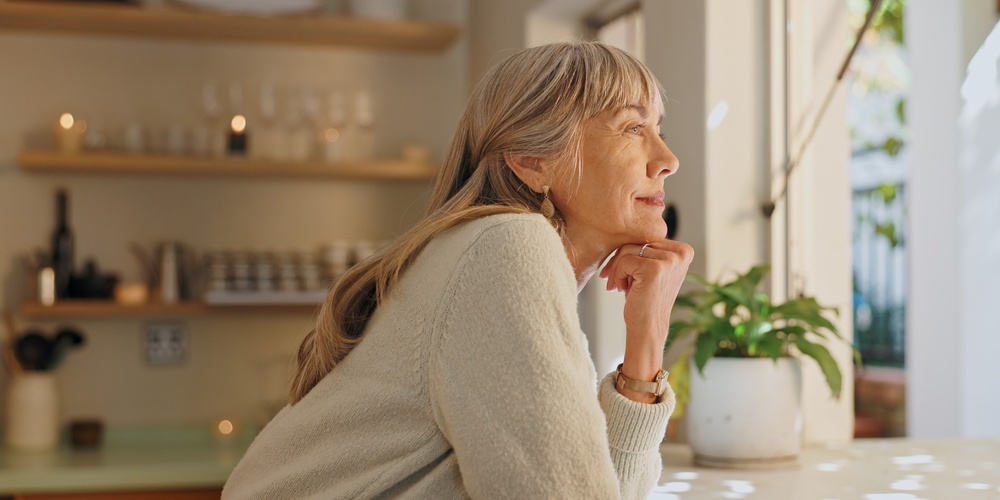 Woman looking out a sunny window