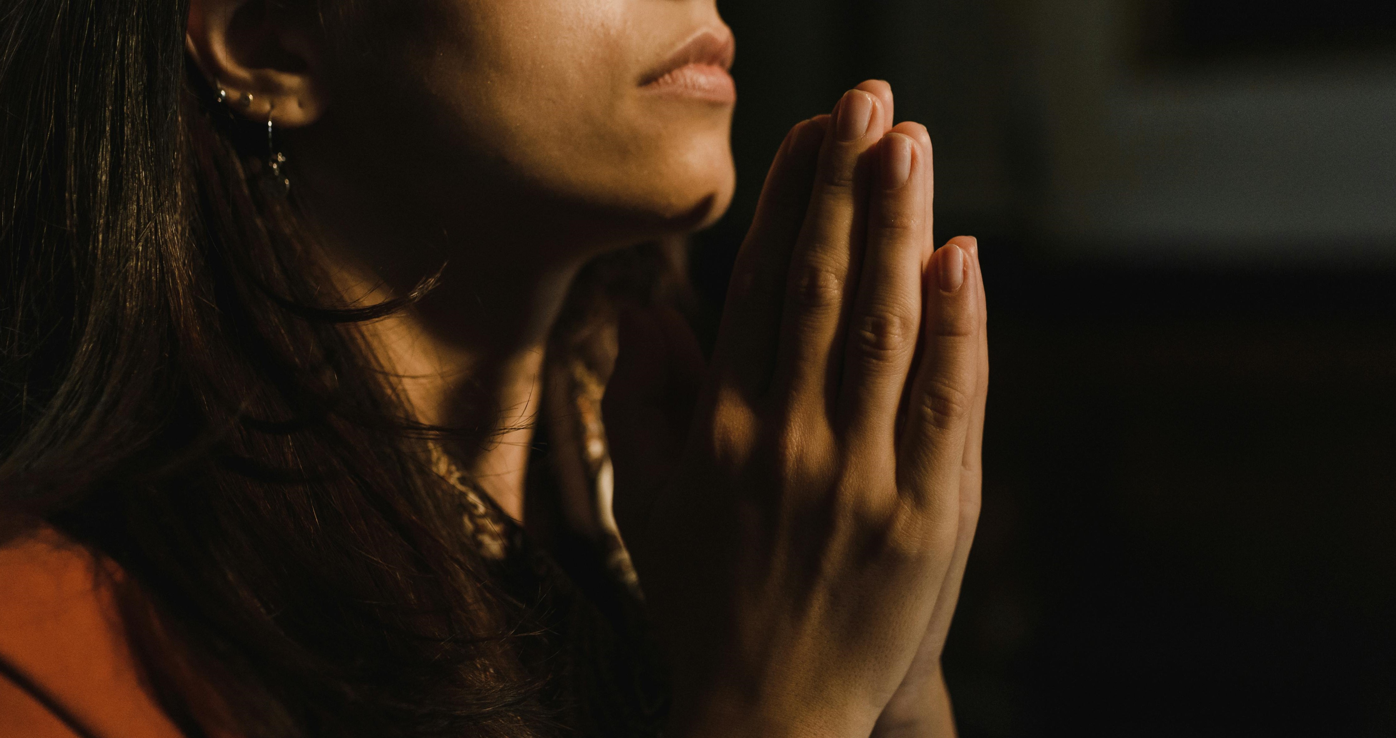 Woman with her hands together in prayer